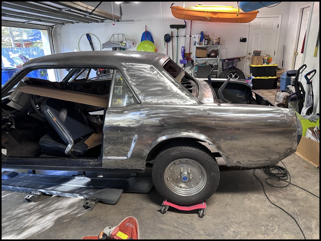 Driver-side view of the roof sail and rear fender after paint removal.