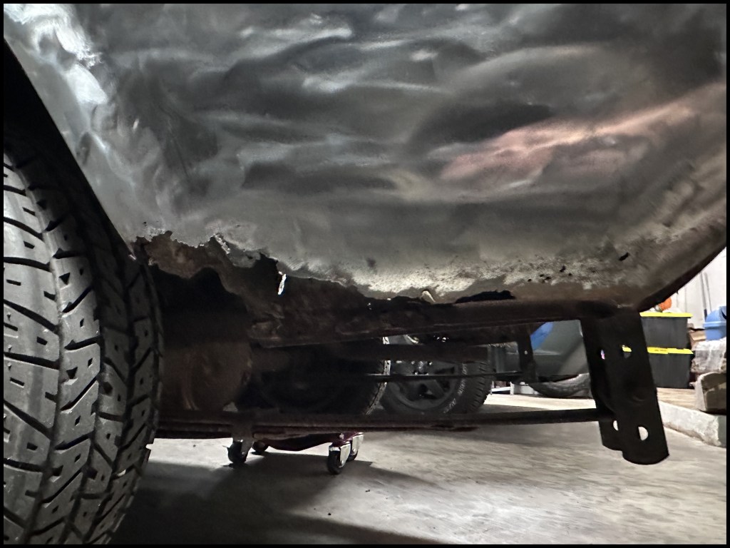 Outer lower rear driver-side fender rust rot damage.