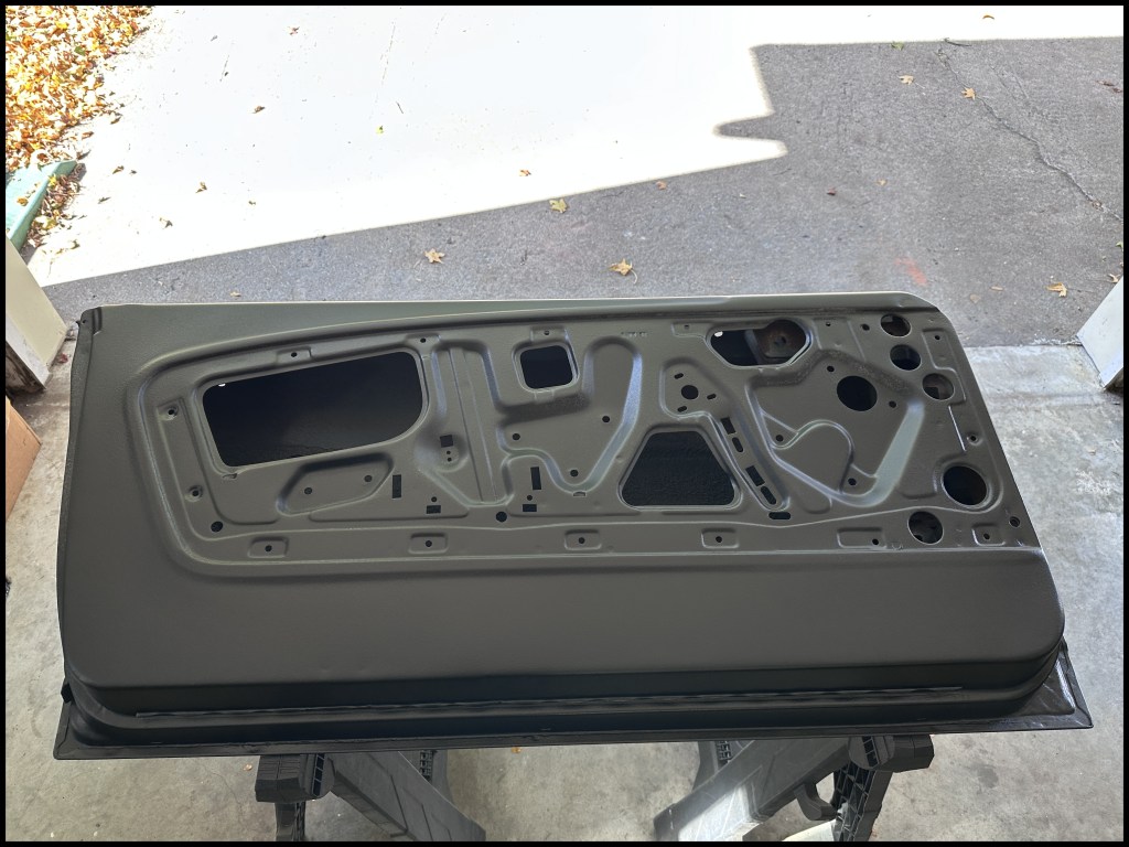 Close-up top view of the inner driver-side door after prep and coating applied.